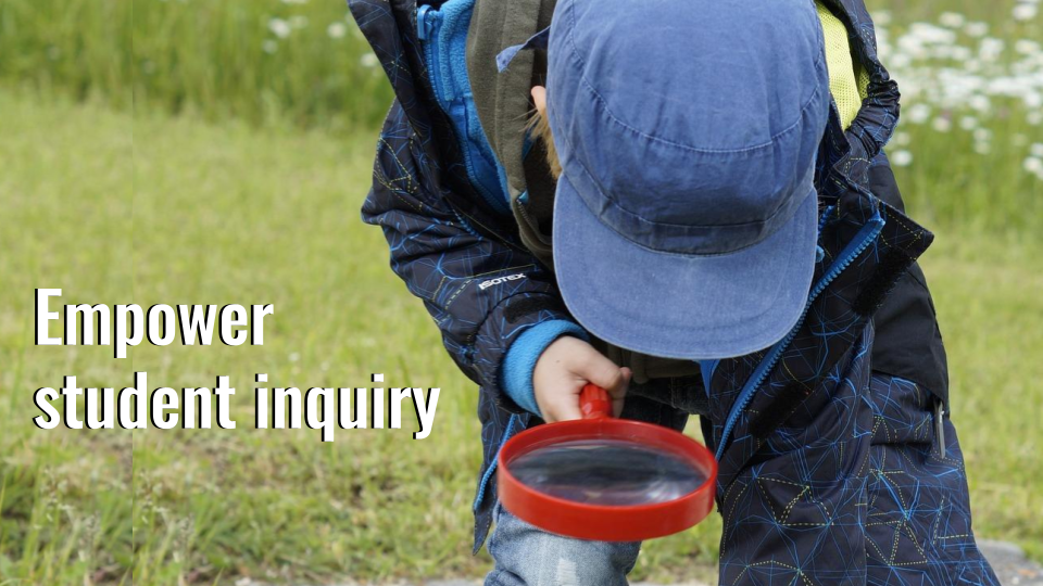 image of young child looking at the ground through a magnifying glass